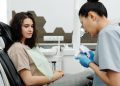 Consultório odontológico com o dentista e o paciente.