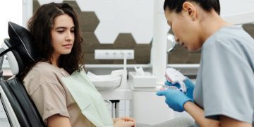 Consultório odontológico com o dentista e o paciente.